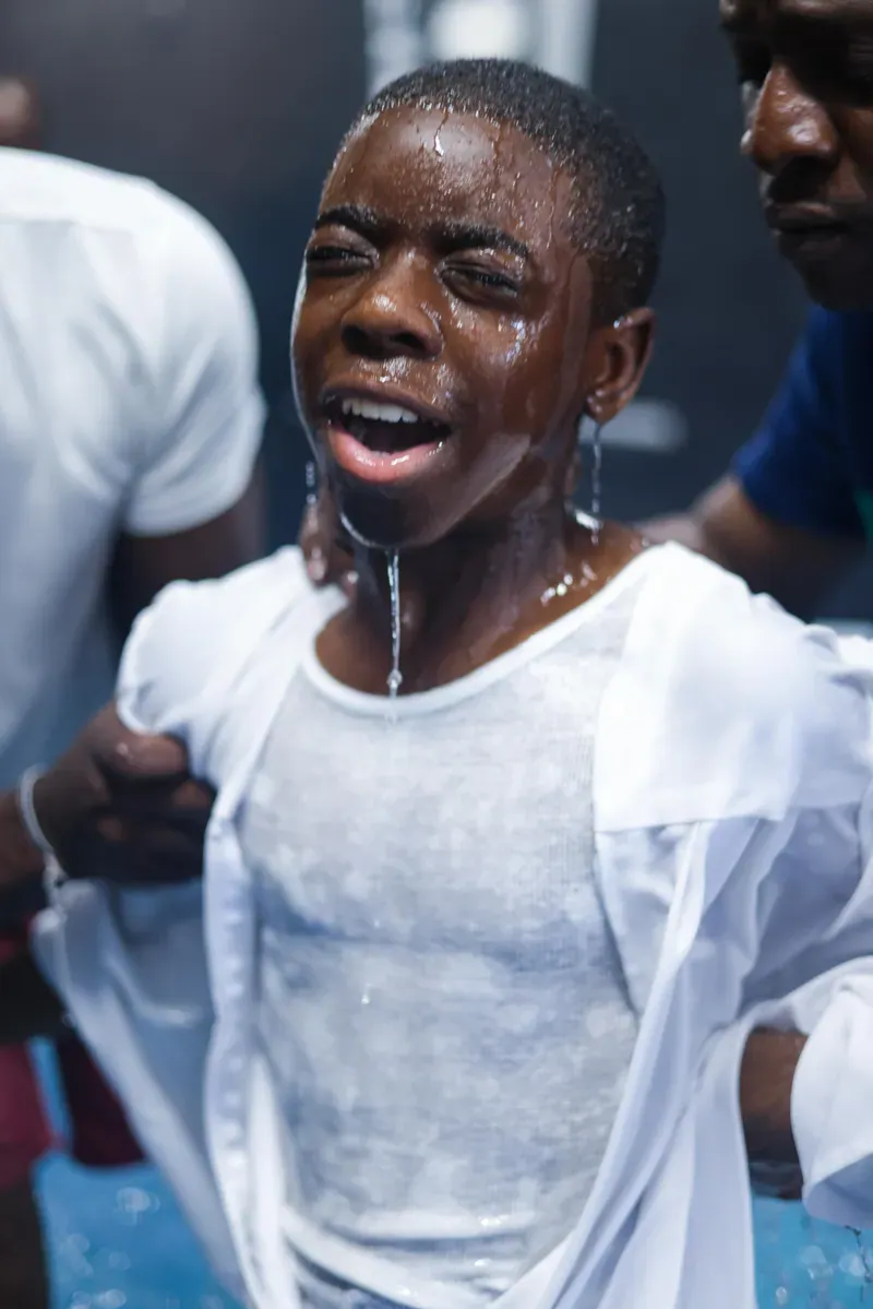 A young person rejoicing moments after baptism