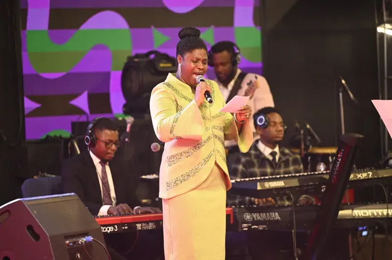 A choir leader singing with the band