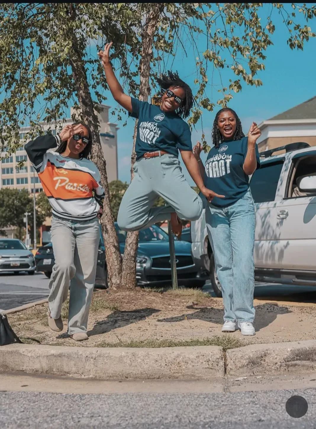 Three friends leaping with joy outside the venue