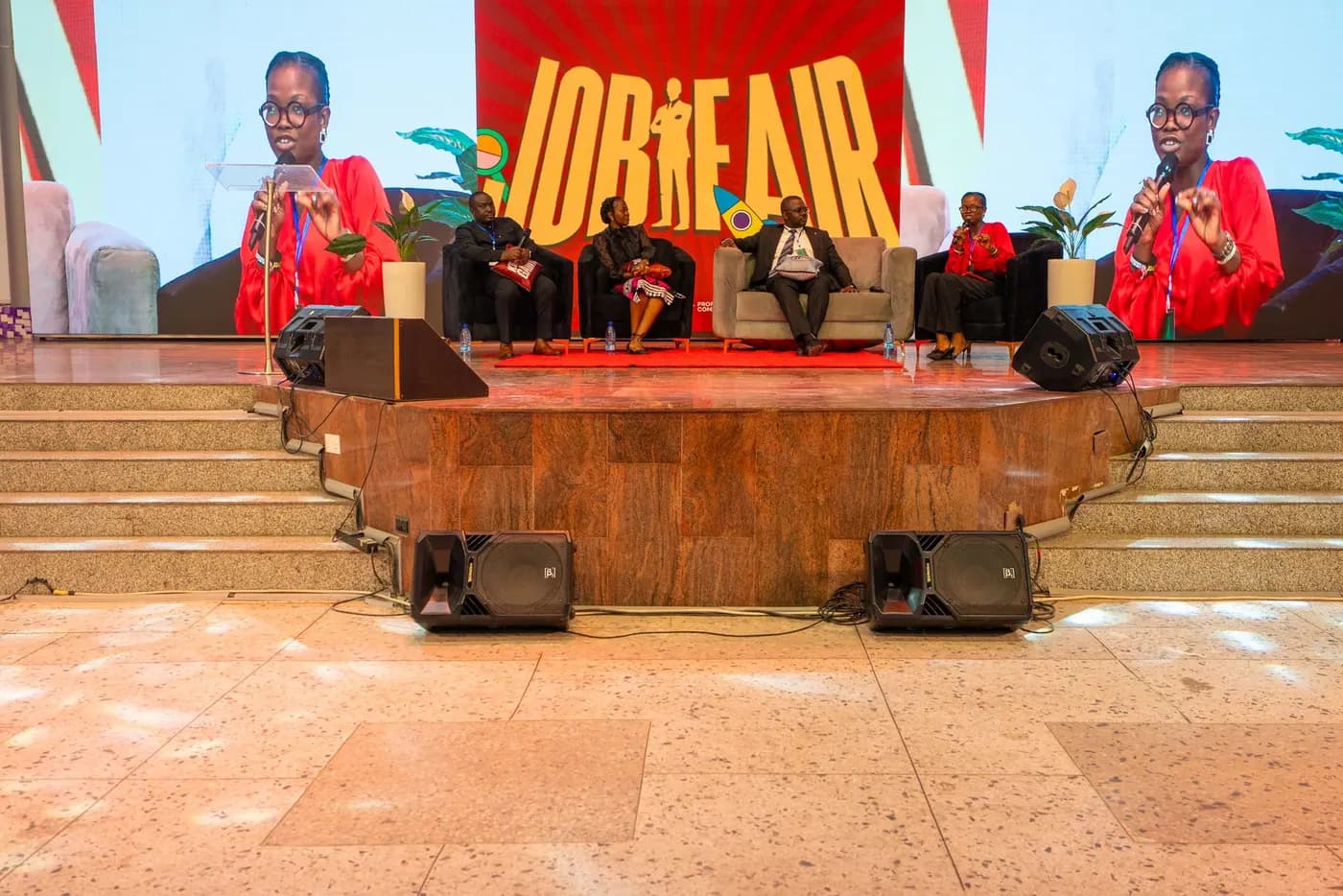 A panel discussion on the job fair stage with the JOB FAIR backdrop