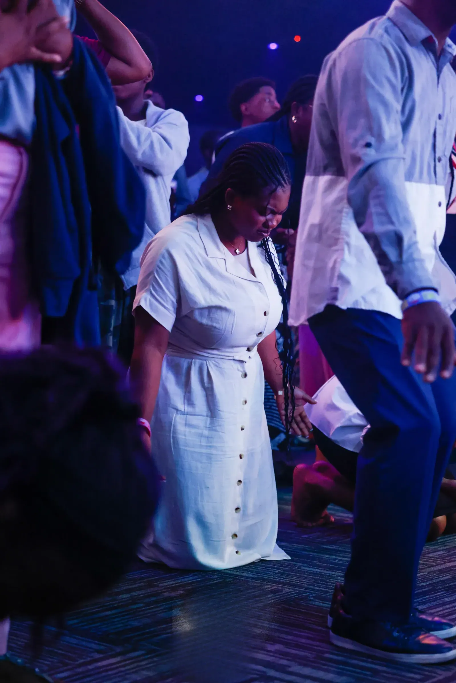A woman kneeling in prayer during the service