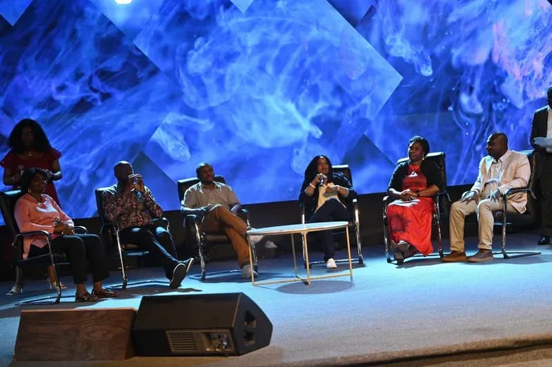 Speakers seated for a panel discussion on stage