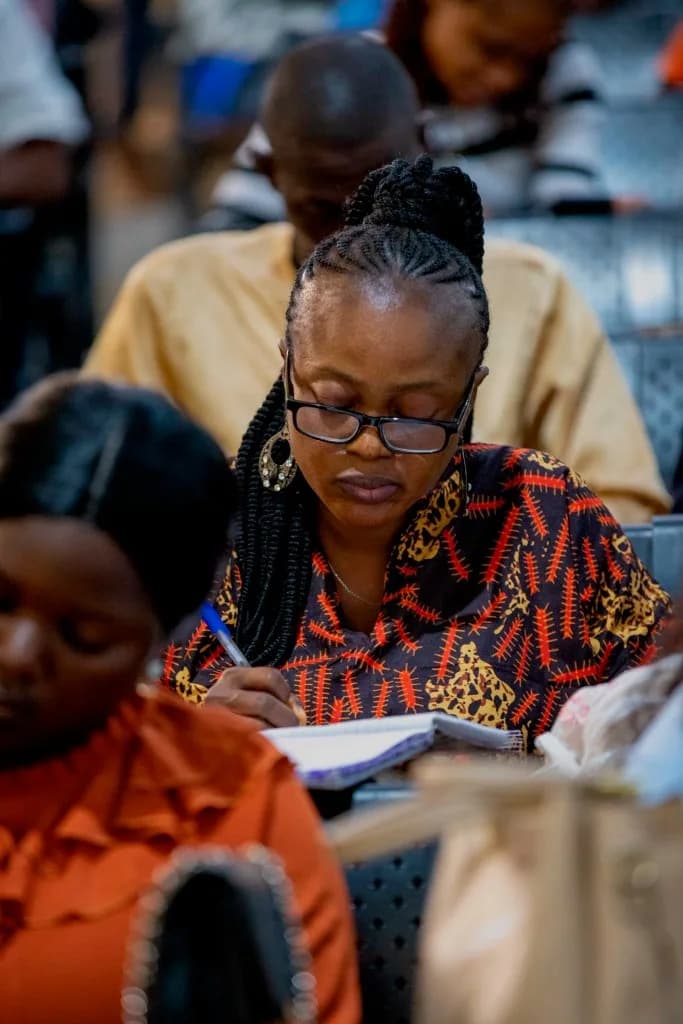 A delegate taking notes during a session at AYAC