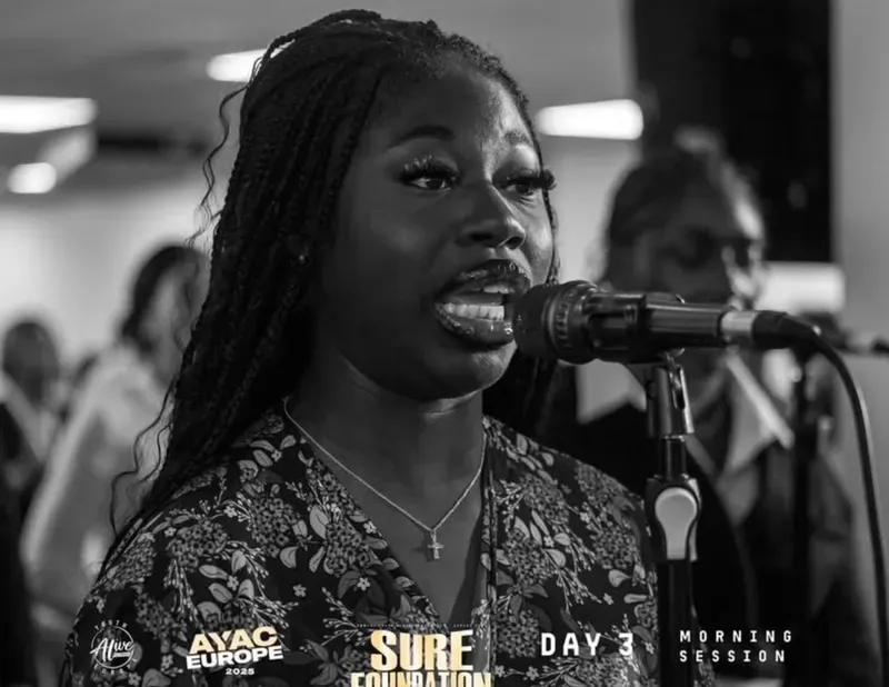 A vocalist singing into the microphone during worship