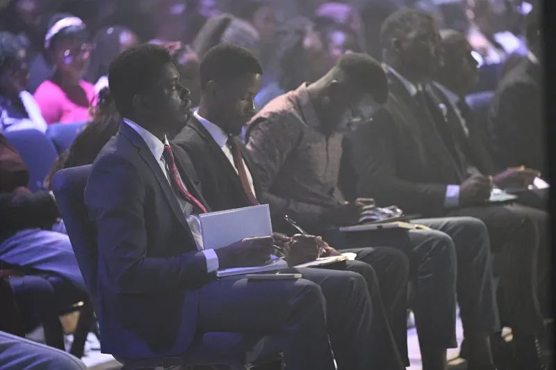Young men in suits taking notes during a session