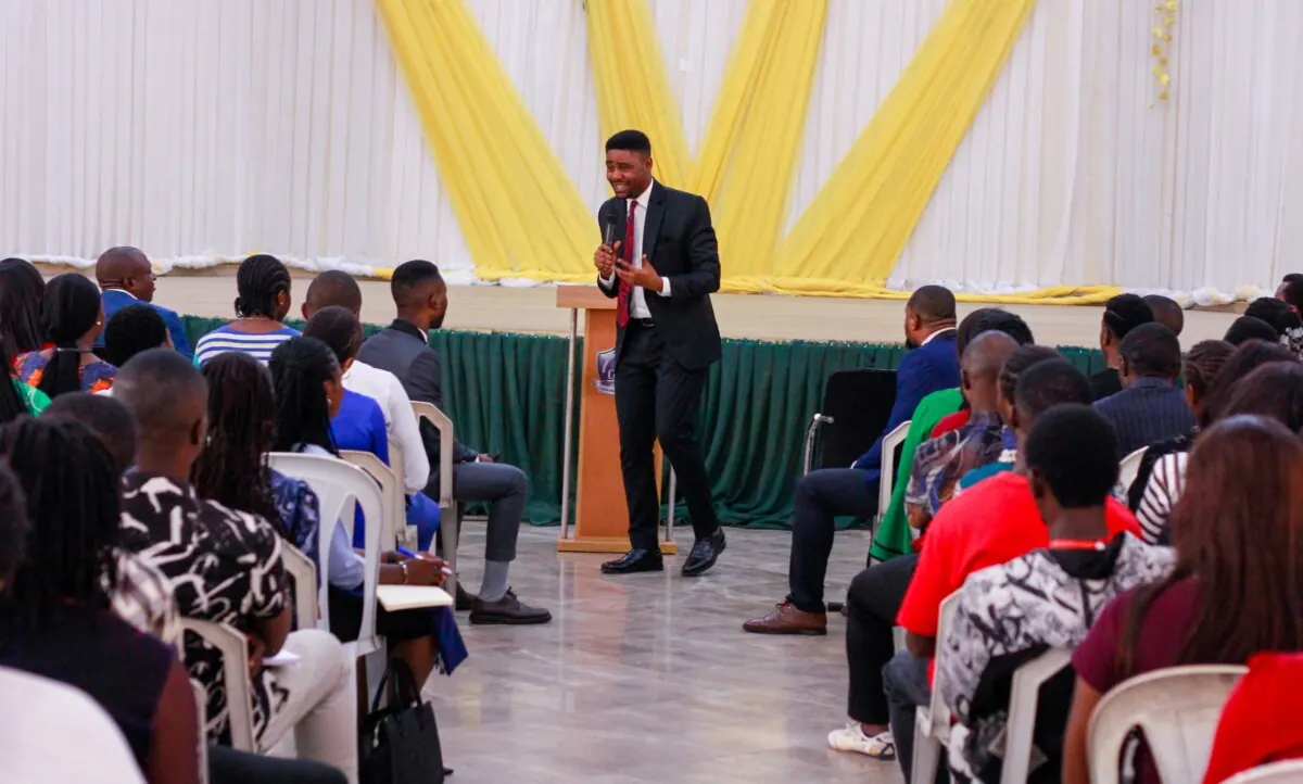 A workshop minister teaching beneath yellow drapes