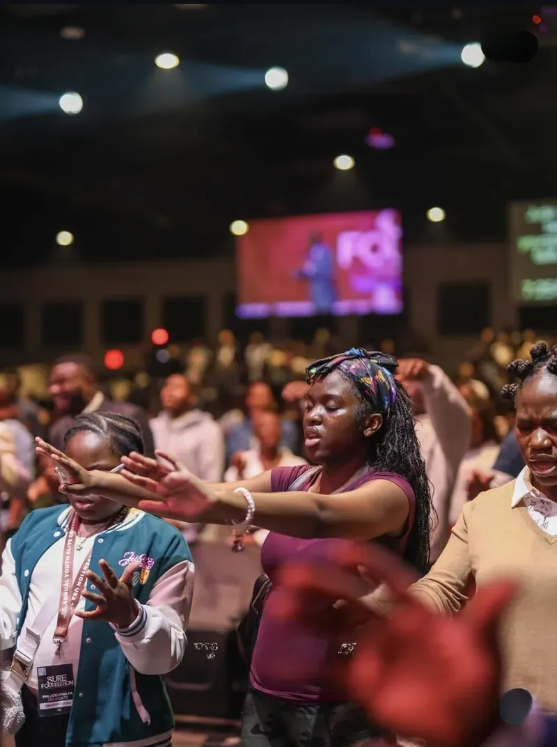 A young woman worshipping with hands outstretched at the convention